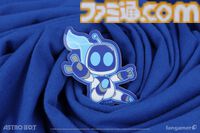 『アストロボット』躍動感あふれるアストロを描いたTシャツが登場。角度によって表情が変化するレンチキュラーピンバッジとあわせて本日（5/22）発売