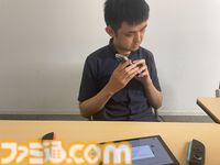 野澤さんがスマホの写真機能でSwitchの画面を写し、視覚障害者支援ソフトSeeing AIで読み上げしているところ